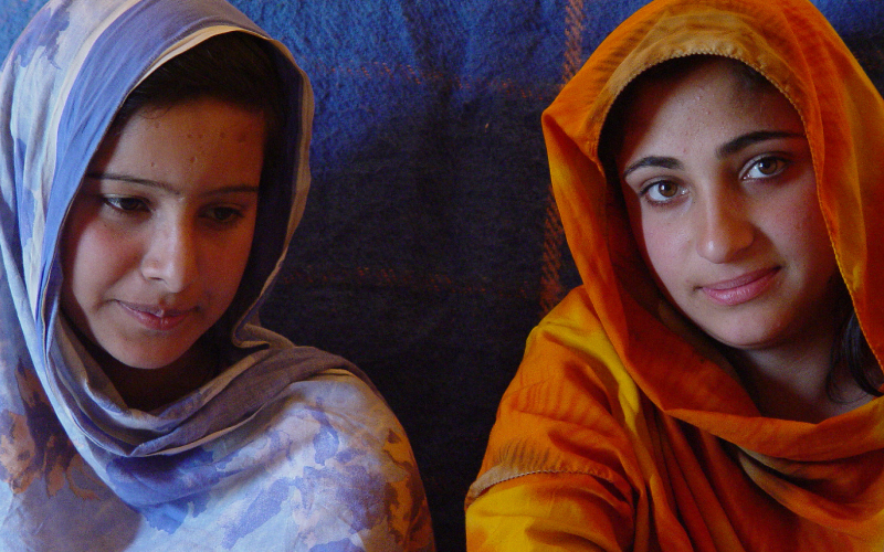 Two displaced adolescent girls sit together